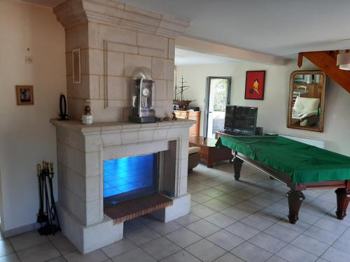 un salon avec une cheminée et une table verte dans l'établissement Au chêne vert, à Saumur