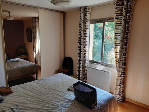 une chambre avec un lit et une fenêtre dans l'établissement Au chêne vert, à Saumur