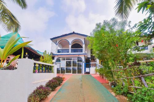 a house with a walkway in front of it at OYO Royal Castle Near Baga Beach in Baga