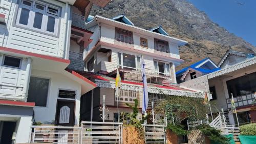 a row of houses in front of a mountain at Udaan Tashi Gakhil Resort in Lachung
