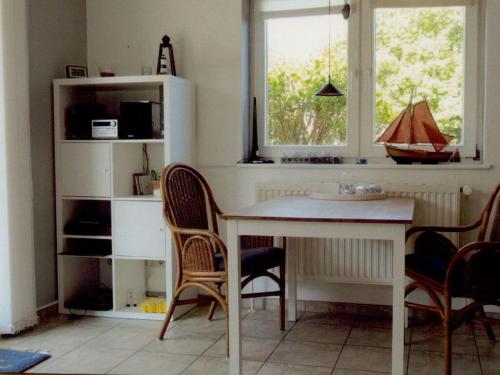 a kitchen with a table and chairs and a window at Seebergweg Modern retreat in Maasholm-Bad