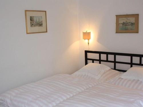 - un lit blanc dans une chambre avec une lampe dans l'établissement View of the Schlei in the Landhaus Schlei, à Bohnert