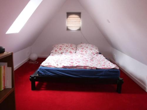 Schlafzimmer mit einem Bett und einem roten Teppich in der Unterkunft Cozy apartment on the canal in Friedrichstadt