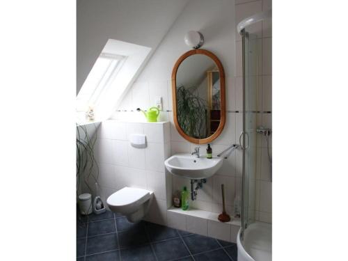 ein Bad mit einem Waschbecken und einem Spiegel in der Unterkunft Cozy apartment on the canal in Friedrichstadt