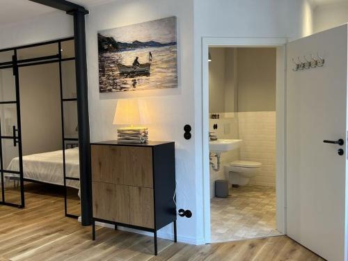 - une chambre avec un lit et une salle de bains dans l'établissement Simmerdeis on the Gracht - Loft1, à Friedrichstadt
