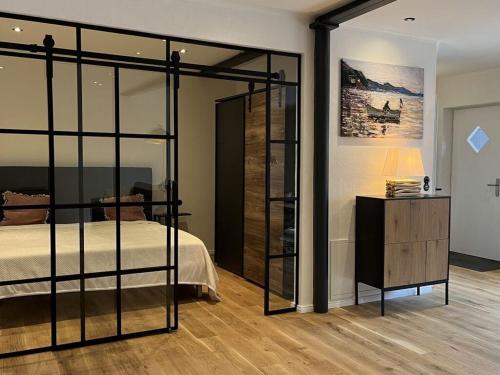 - une chambre avec un lit et un mur en verre dans l'établissement Simmerdeis on the Gracht - Loft1, à Friedrichstadt