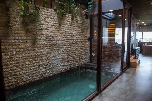 a swimming pool in front of a brick wall at Midgard house in Dalung