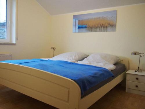 ein Schlafzimmer mit einem Bett mit einer blauen Decke in der Unterkunft Deichwiege Modern retreat in Horumersiel