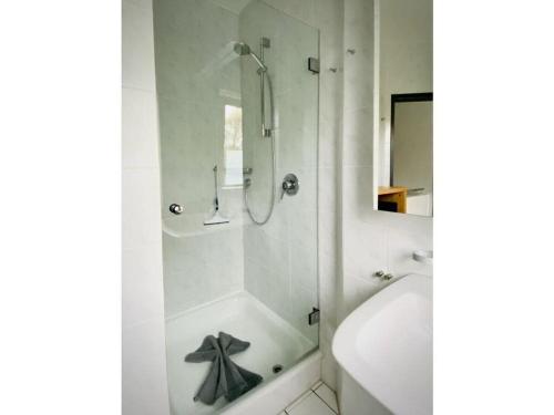 y baño blanco con ducha y bañera. en Christel Modern retreat, en Langeoog
