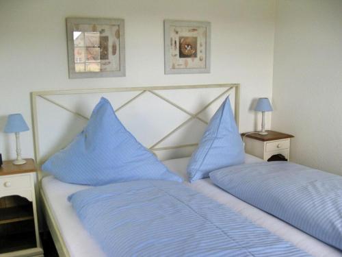 蘭圖姆的住宿－Haus Ruusenhoog - Apartment 7，一间卧室配有两张带蓝色枕头的床