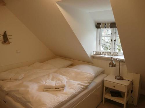 Una cama blanca en una habitación con ventana. en Favorite place Modern retreat, en Wrixum