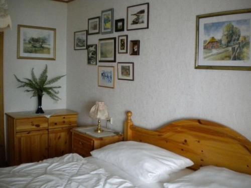 ein Schlafzimmer mit einem Bett und einer Kommode und Bildern an der Wand in der Unterkunft North Sea dike Modern retreat in Sehestedt