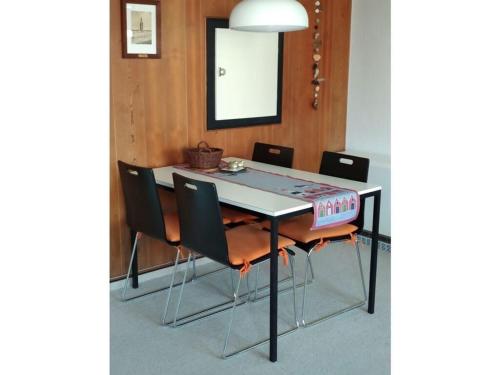 a dining room table with chairs and a mirror at near the beach Modern retreat in Wangerooge