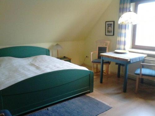 a bedroom with a bed and a table and chairs at Oland in the Halligblick house in Dagebüll