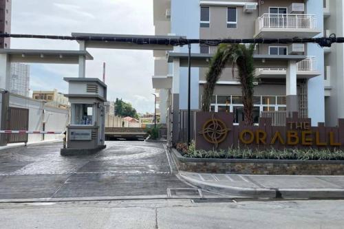 a bus stop in a parking lot next to a building at DMCI TheOrabella QC,1 BR w/bal in Cubao38sqm condo in Manila