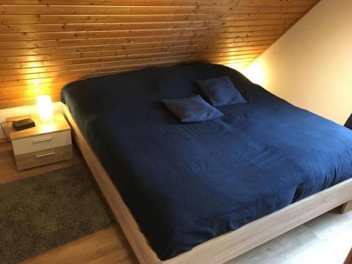 a bedroom with a large bed with a wooden wall at somewhere else Modern retreat in Neßmersiel