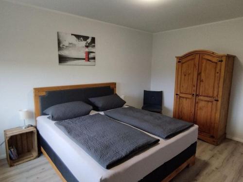 a bedroom with a bed and a wooden cabinet at Little Freedom Modern retreat in Friedrichsau