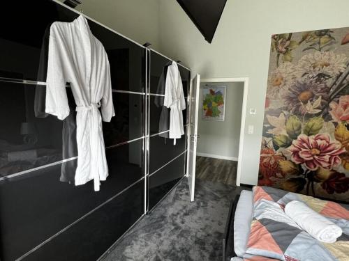 ein Schlafzimmer mit Bademänteln an der Wand in der Unterkunft Farsighted modern retreat in Zetel