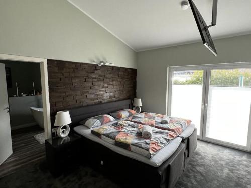 ein Schlafzimmer mit einem Bett und einer Ziegelwand in der Unterkunft Farsighted modern retreat in Zetel