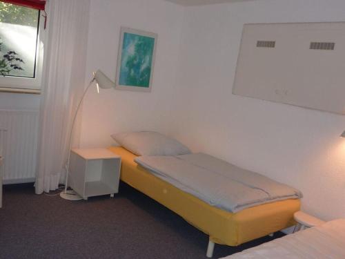 a small room with two beds and a window at Maiken Feikes, Am Friedrichshain 2 in Wenningstedt