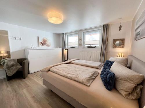 a bedroom with a large bed and a couch at Porthole in the Seute Deern house in Juist