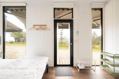 a bedroom with a bed and a large glass door at Forest View Cottage 1 in Jiaoxi