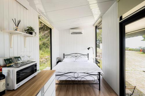 Forest View Cottage 2 في جياوكسي: غرفة نوم في منزل صغير مع سرير