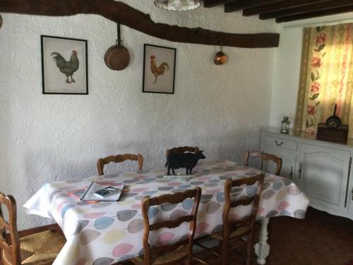 une table avec un chat assis sur le dessus dans l'établissement Ma petite normande, à Neuville-lès-Dieppe