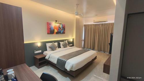 um quarto de hotel com uma cama e uma secretária em Swarnam Hotel em Old Goa