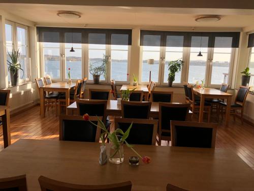 a restaurant with tables and chairs and windows at ÖMC Kurshotell in Öckerö