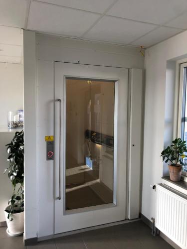 a sliding glass door in a room with plants at ÖMC Kurshotell in Öckerö