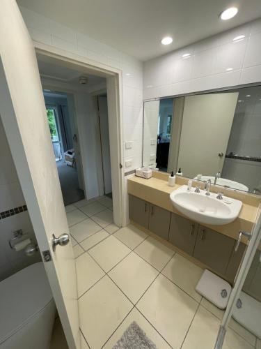 W łazience znajduje się umywalka i lustro. w obiekcie Secluded tropical apartment w mieście Palm Cove