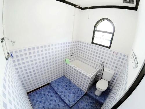 uma pequena casa de banho com banheira e WC em Guest House MW 46 by NmRooms em Demangan