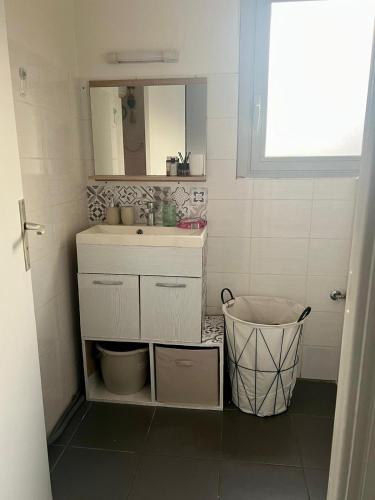 une salle de bain avec un lavabo et un miroir dans l'établissement Cozy Studio Near Promenade, à Nice