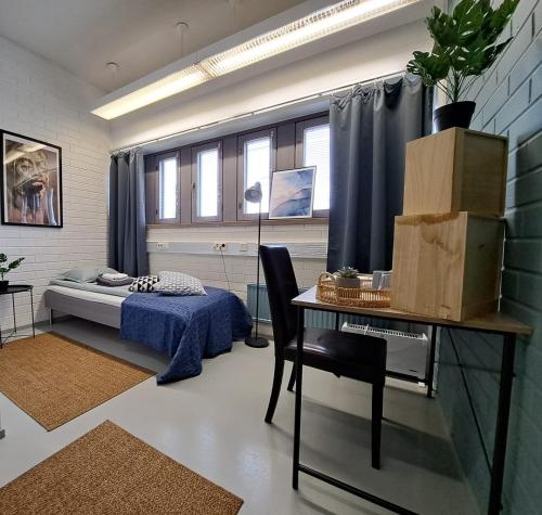 a bedroom with a bed and a desk and a table at WatchHouse in Hamina