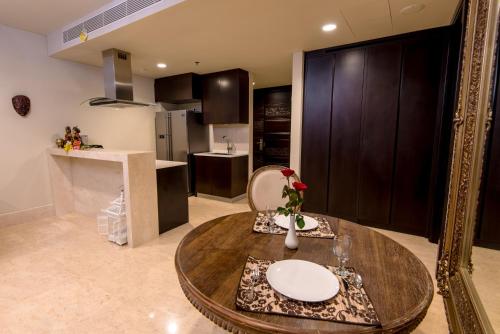 a living room with a table and a kitchen at Luxury Apartment at AYANA Residences in Jimbaran