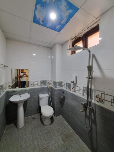 y baño con aseo, lavabo y ducha. en Khách sạn Viễn Đông en Dong Quan
