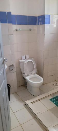 a bathroom with a toilet and a tiled floor at Elfiehomes in Nairobi