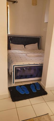 a bedroom with a bed with blue shoes on the floor at Elfiehomes in Nairobi
