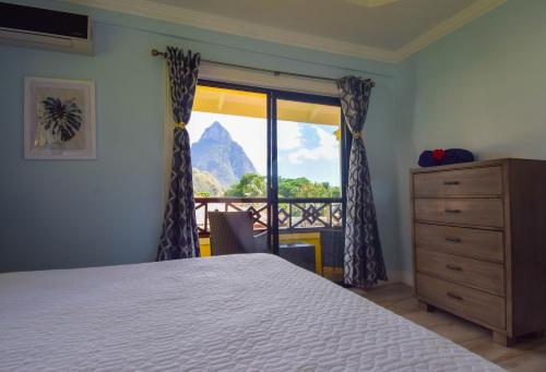 a bedroom with a bed and a window with a view at Sea Piton Apartment - Piton Delight- Certified in Soufrière