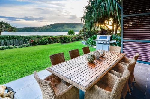 a wooden table and chairs on a patio at Yacht Club Villas on Hamilton Island by HIHA in Hamilton Island