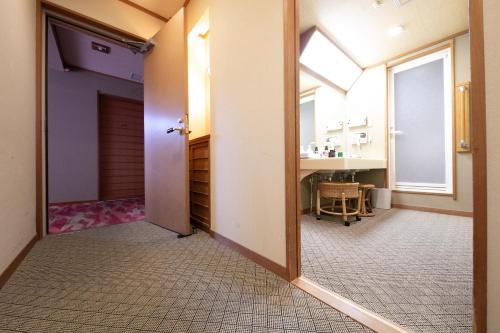 Habitación con baño con espejo y lavabo. en Genjiko, en Minamichita
