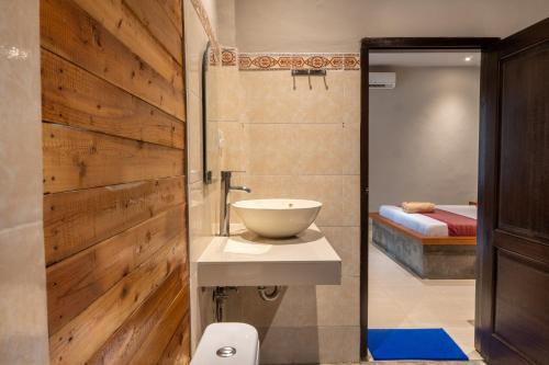 a bathroom with a bowl sink and a bed at Warsa's Garden Bungalow and Spa in Ubud