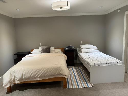 a bedroom with two beds and a rug at Charming Modern Home Near Downtown and UBC in Vancouver