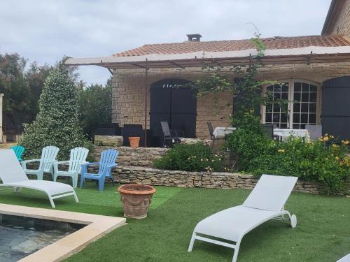 een groep stoelen op het gras bij een zwembad bij Villa de 3 chambres avec piscine privee jardin clos et wifi a Aubignan in Aubignan
