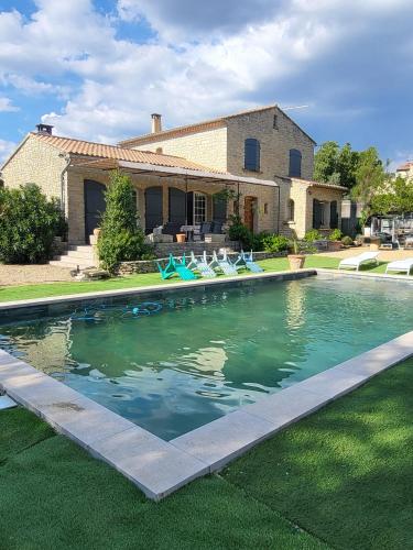- une piscine avec des chaises en face d'une maison dans l'établissement Magnifique villa avec piscine privée à Aubignan, à Aubignan