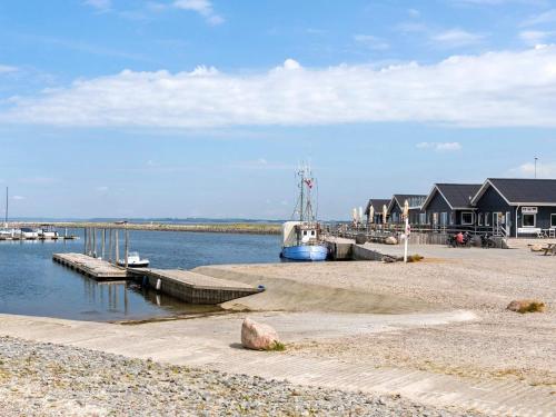 a dock with a house and a boat in the water at 5 star holiday home in Vinderup-By Traum in Vinderup