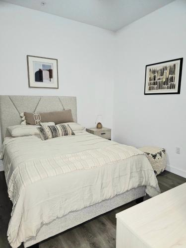 Landmark @ 67th Ave في غليندال: غرفة نوم بيضاء مع سرير كبير وطاولة