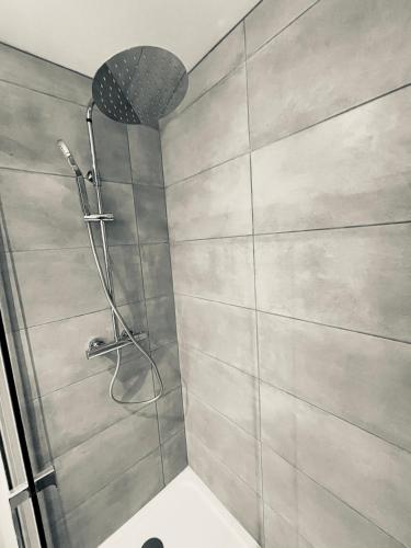 une douche avec pommeau de douche dans une salle de bain dans l'établissement L’échappée Mer, au Havre