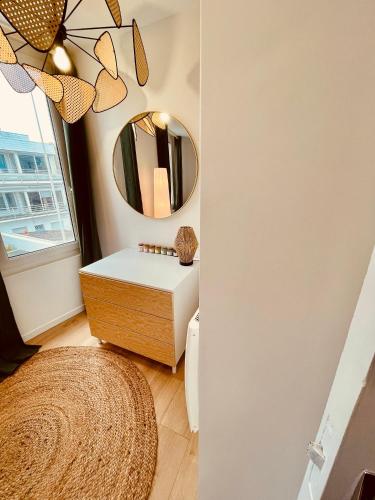 une salle de bain avec un lavabo et un miroir dans l'établissement L’échappée Mer, au Havre